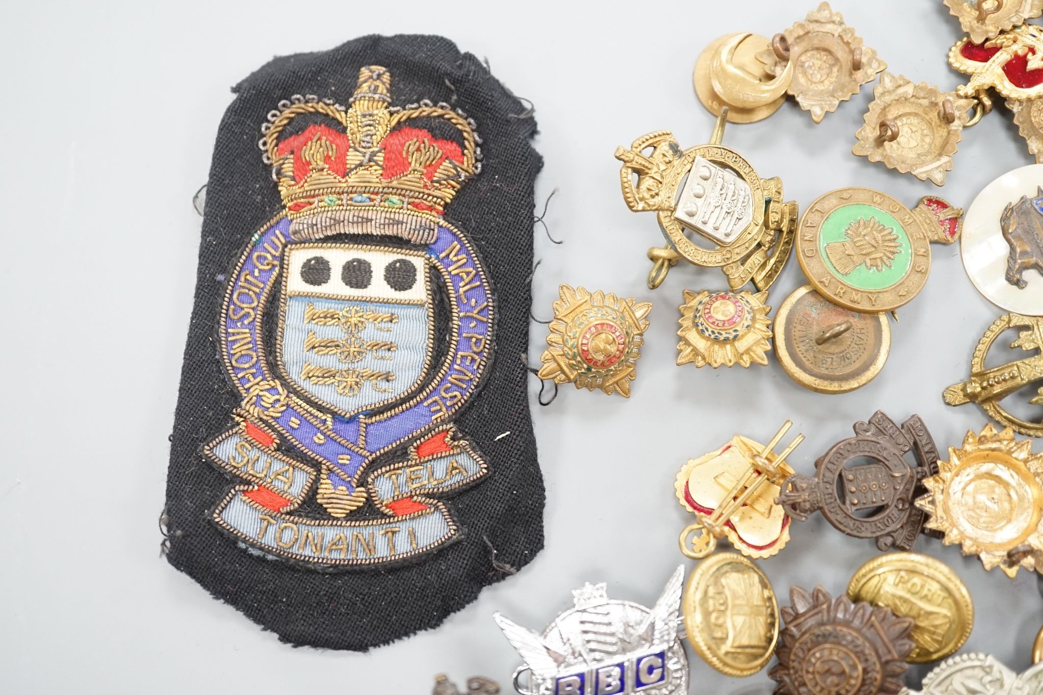 A quantity of cap badges, buttons and badges